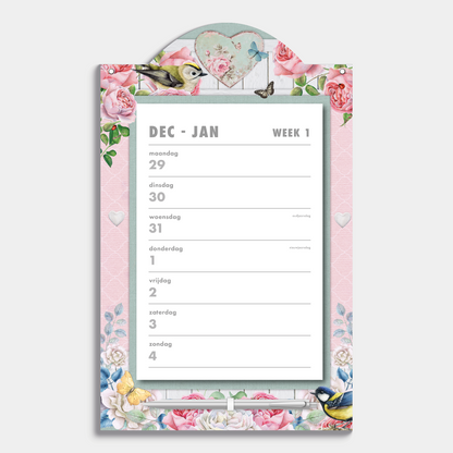 Scheurkalender 2026 op een kartonnen bord voorzien van een vrolijk brocante motief met rozen, vlinders en vogels, met pen – vooraanzicht.