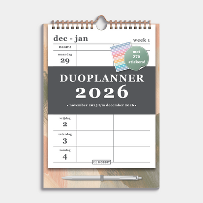 Duoplanner 2026 A4 met een dessin van abstracte verfstreken op een kartonnen bord met pen – vooraanzicht.