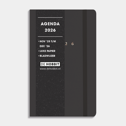 A6 agenda 2026 met suèdelook cover in antraciet, harde cover en stevige elastieken sluiting – vooraanzicht met informatieve banderol.