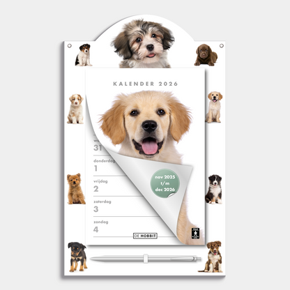 Scheurkalender 2026 op een kartonnen bord voorzien van foto's van lieve honden en puppies, met pen – vooraanzicht.